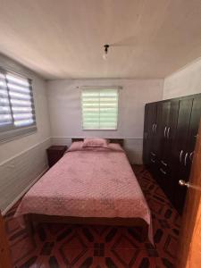 a small bedroom with a bed and a window at Refugio Costero in Caldera