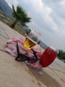 a pair of wine glasses sitting on the beach at JandJ Guest House in Armburg