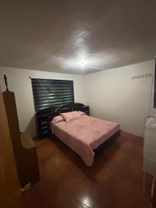 a small bedroom with a bed and a window at Refugio Costero in Caldera