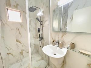a white bathroom with a sink and a shower at Bohemian & White Getaway Zone4 in Abidjan +77 photos