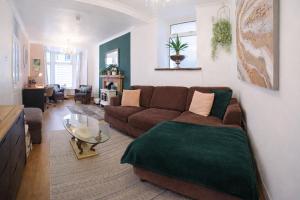 a living room with a couch and a table at Walk to Town, Parking, Family Home, drive to beach in Bridgend