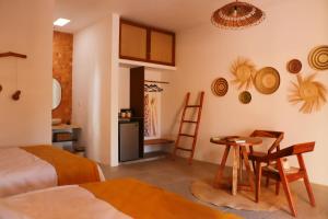 a room with a bed and a table and a kitchen at Hotel Aldea Katún in Izamal