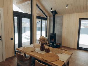 a dining room with a table and a fireplace at Zarichna Cottage in Podgorodtsy