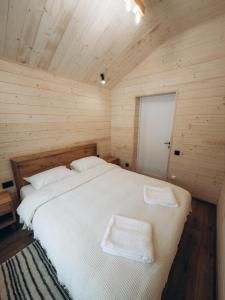 a bedroom with a bed with two towels on it at Zarichna Cottage in Podgorodtsy