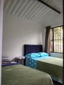 a bedroom with two beds and a window at Mi Cabaña in Nimaima