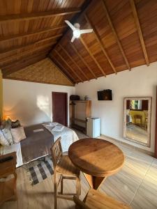 a bedroom with a bed and a table and a tableablish at Pousada Chalés Jatobá in Prados