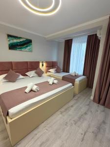 a bedroom with two beds and a large window at MavCity Boutique in Constanţa