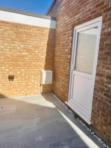 a brick building with a door and a window at Large Double Bed En-suite Room 20 mins from Heathrow in Burnham