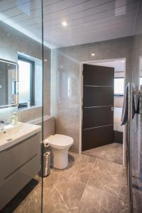 a bathroom with a toilet and a sink and a shower at Lewis Living in Isle of Lewis +37 photos