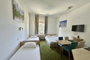 a hotel room with two beds and a table at Apartments Konaci Kopaonik in Kopaonik