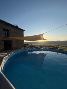 a swimming pool with the sunset in the background at Masía Casa Rullo in Allepuz