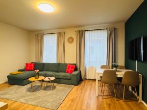 ein Wohnzimmer mit einer grünen Couch und einem Tisch in der Unterkunft White Inn - Statement in Mürzzuschlag