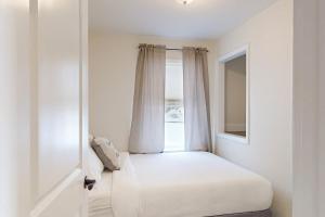 a white room with a window and a bed at Schroon Lake Retreat in Schroon Lake