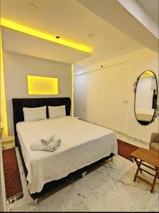 a bedroom with a large white bed with a mirror at My Palace Villa Heated Pool in Belek