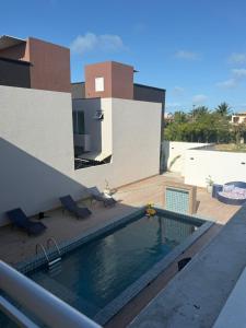 a swimming pool on top of a building with a house at Divine Duplex Próximo ao Oficina 23 Kite Surf in Caucaia