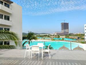 a patio with a table and chairs next to a swimming pool at Apartment with lagoon view mas amenities in Mazatlán