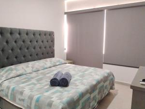 a bed with two pairs of shoes sitting on it at Apartment with lagoon view mas amenities in Mazatlán
