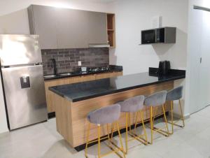 a kitchen with a counter and a refrigerator at Apartment with lagoon view mas amenities in Mazatlán +26 photos