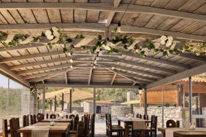 a restaurant with tables and chairs and flowers on the ceiling at Lalloudes Hotel Mani in Éxo Nímfion