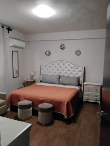 a bedroom with a large bed with two stools at Comfortable apartment, right on the seafront in Mazatlán