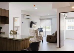 a kitchen and living room with a counter and chairs at Premium apartment in Laguna Playa with pool in Mazatlán