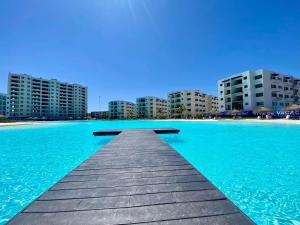 a dock in the water with buildings in the background at Premium apartment in Laguna Playa with pool in Mazatlán