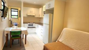 a small kitchen with a table and a refrigerator at The Denman Lodge in Brisbane