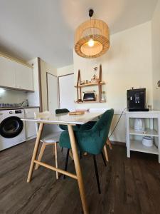 a kitchen with a table and chairs in a room at Le cosy des Sables Blancs in Douarnenez