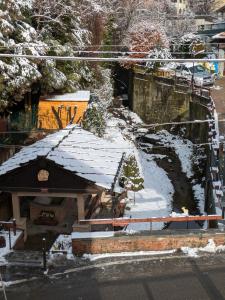 a building with snow on it next to a river at Il Nido sul Torrente in Coazze
