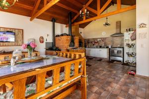 a large kitchen with wooden ceilings and a large table at Refúgio de Montanha em Monte Verde para Famílias e Amigos com 4 Suítes in Monte Verde