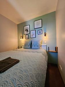 a bedroom with a large bed with three pictures on the wall at Le cosy des Sables Blancs in Douarnenez