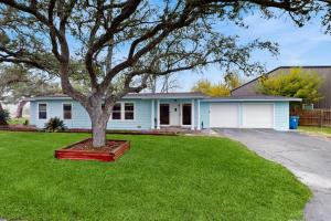 a blue house with a tree in the yard at The Lazy Oak Retreat in Rockport