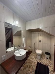 a bathroom with a sink and a toilet at Pousada Chalés Jatobá in Prados +10 photos