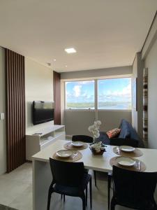 a living room with a table and chairs and a television at Flat aconchegante em Recife in Recife