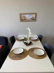 a table with plates and flowers on top of it at Flat aconchegante em Recife in Recife