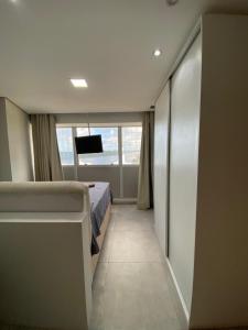 a bedroom with a bed and a television in it at Flat aconchegante em Recife in Recife