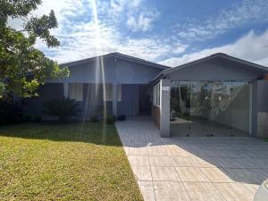a house with a building with a large glass door at Xangri-lá Beach House in Xangri-lá