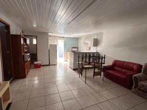 a living room with a red couch and a kitchen at Xangri-lá Beach House in Xangri-lá