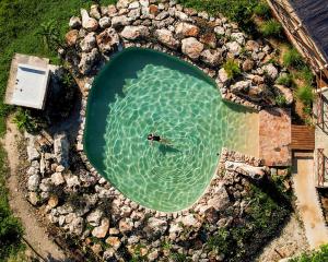 an overhead view of a person swimming in a pool of water at Hotel Aldea Katún in Izamal