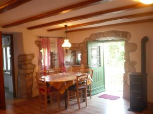 a dining room with a table and a green door at House Dragica in Cres