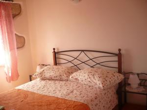 a bedroom with a bed with two pillows at House Dragica in Cres