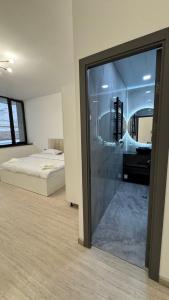 a bedroom with a bed and a glass door with a desk at Prime House in Akunkʼ