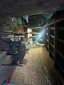 a deck with chairs and a table and a light at Recanto Nativos in Garopaba