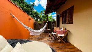 a patio with a hammock and a table and chairs at Vila Bonita Guest House in Alto Paraíso de Goiás