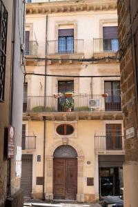 an old building with a door and a balcony at Don Sturzo Apartment in Caltagirone