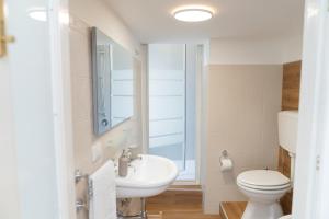 a bathroom with a white toilet and a sink at Don Sturzo Apartment in Caltagirone +18 photos