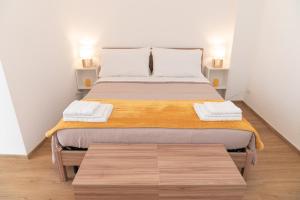 a bedroom with a large bed with two towels on it at Don Sturzo Apartment in Caltagirone