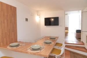 a dining room with a table with chairs and a television at Don Sturzo Apartment in Caltagirone