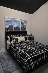 ein Schlafzimmer mit einem schwarz-weißen Bett und zwei Fenstern in der Unterkunft Tiny Space, Big Comfort in Tampa