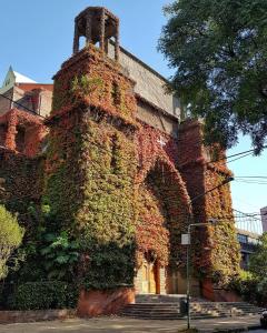 a building covered in ivy on the side of a street at Olivos Stay in Olivos